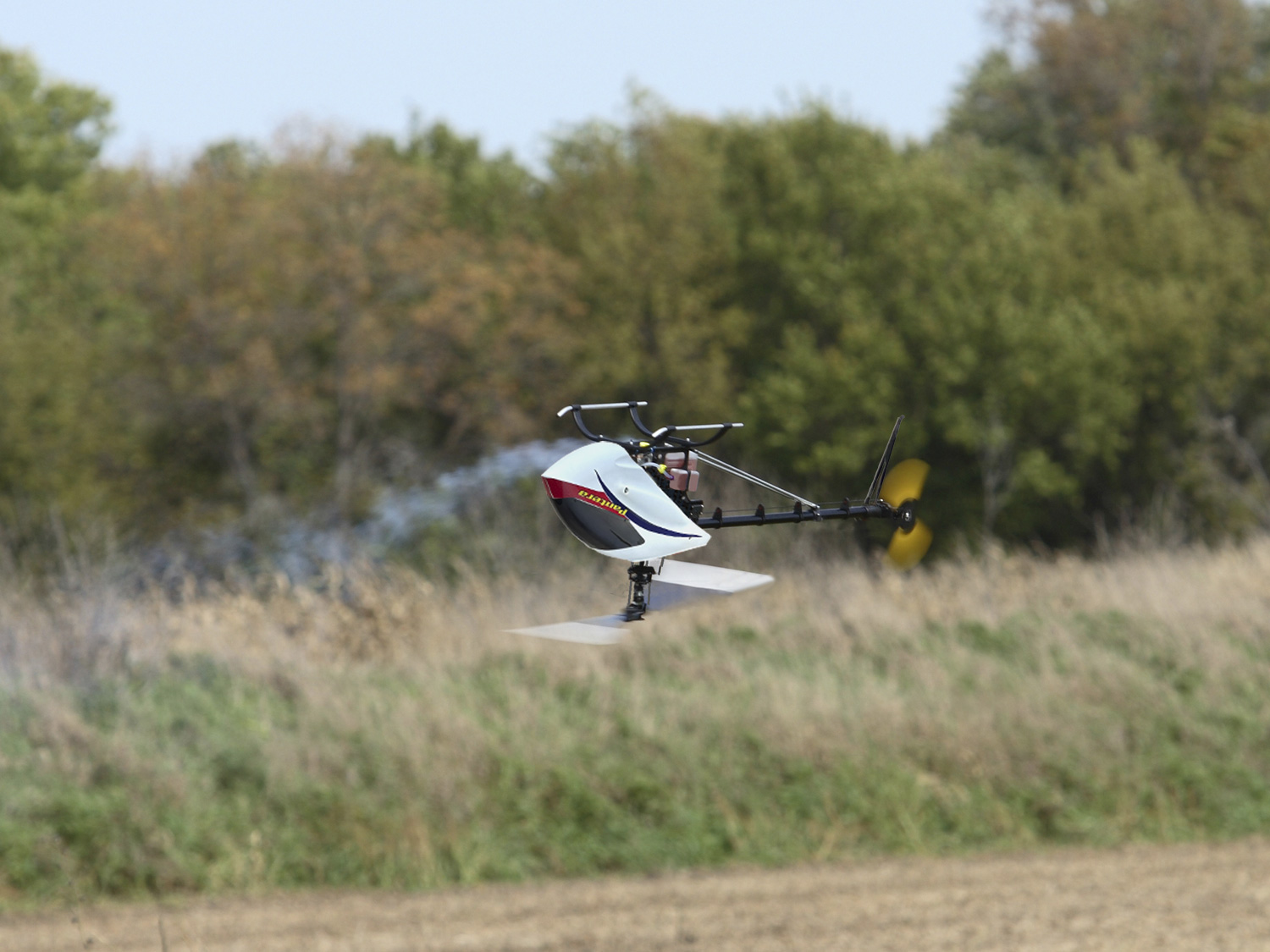 Inverted model helicopter very low to the ground flying tail first
