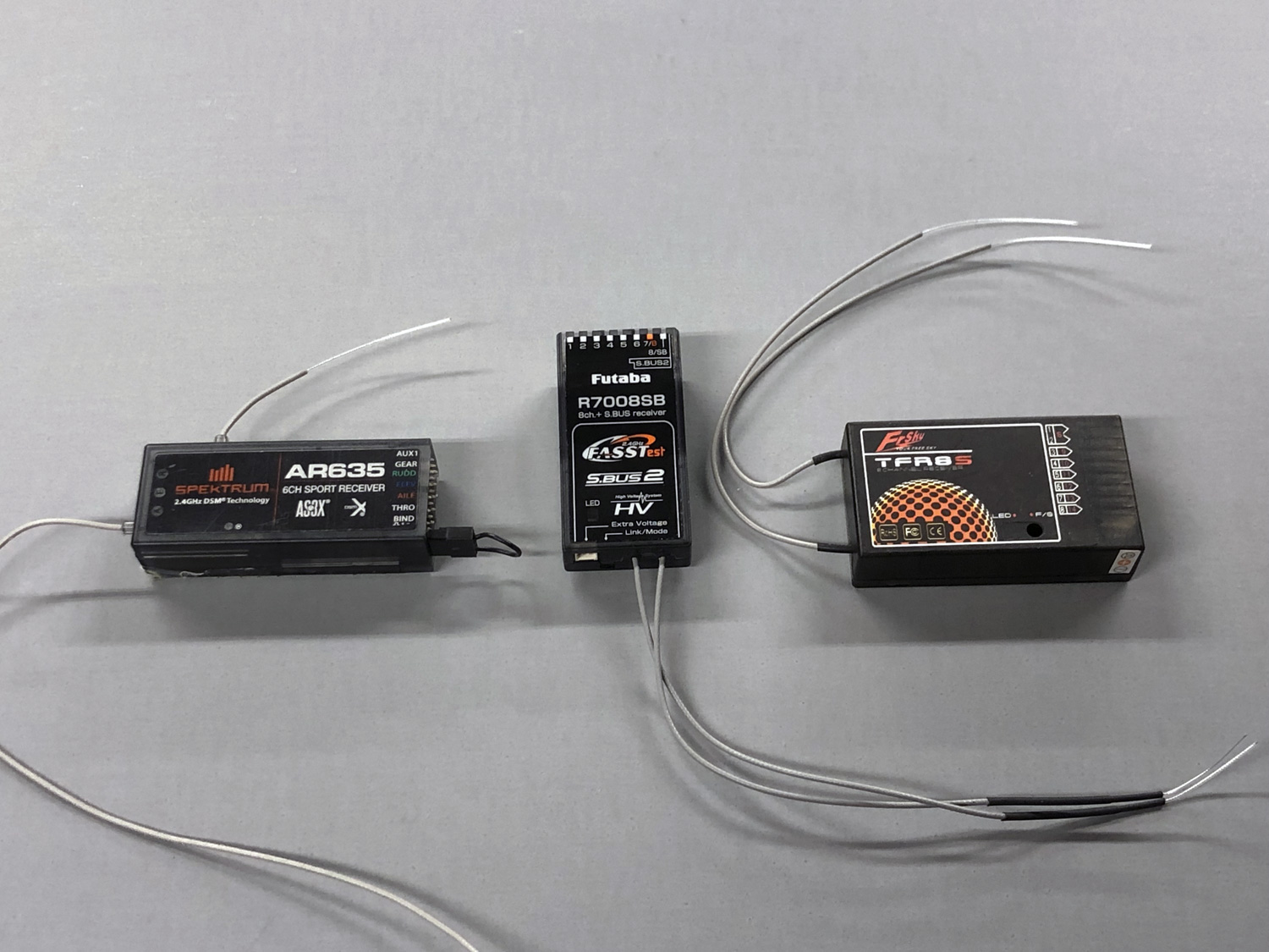 An image against a gray background of Spektrum AR635, Futaba R7008SB, and FrSky TFR8S2400px-rf-systems-rxx3-b.jpg