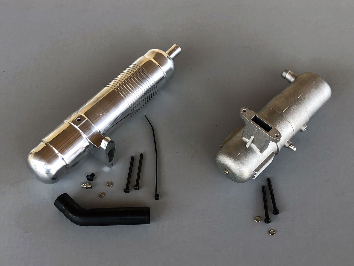 Photo of a pair of exhausts, one a cast aluminum 2pc muffler, the other a highly polished alloy unit